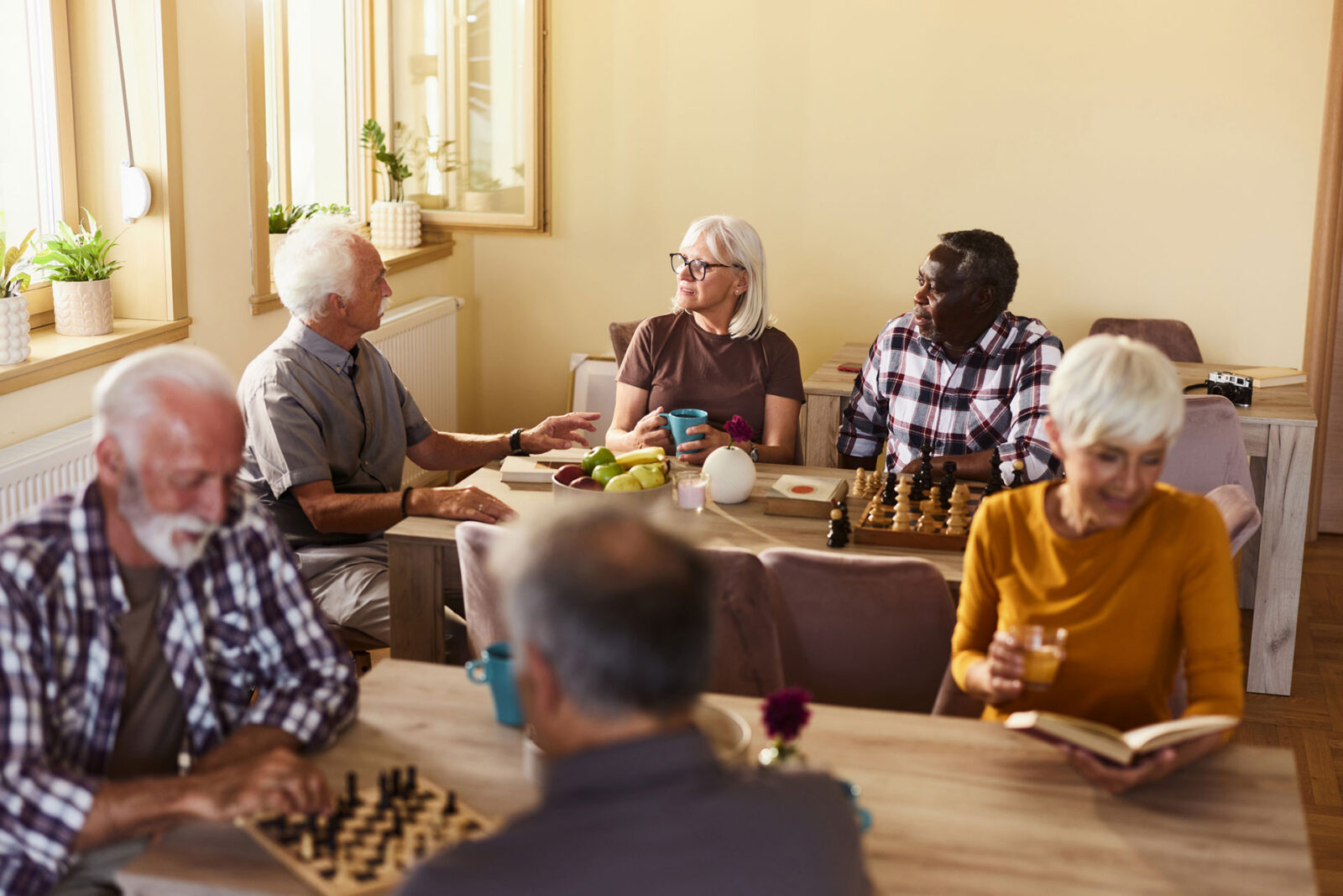 Seniors enjoying conversation and games in a cozy environment.