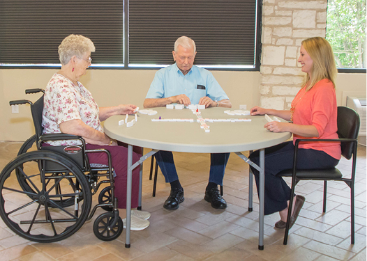 Three people playing a game at a round table.