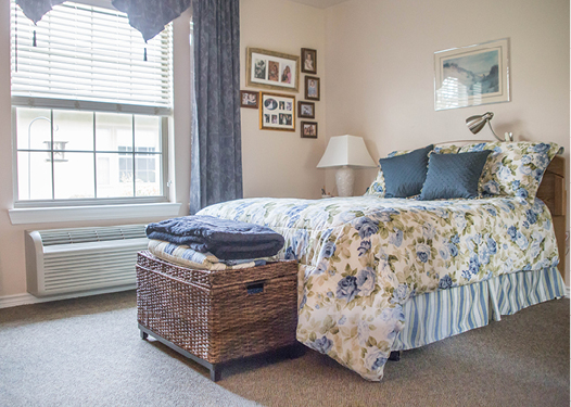 Cozy bedroom with floral bedding, photos, and woven basket.